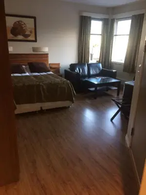 a living room with a bed and a couch at Nordfjord Hotell - Bryggen in Nordfjordeid