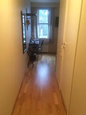 a hallway with a room with a table and a mirror at Nordfjord Hotell - Bryggen in Nordfjordeid