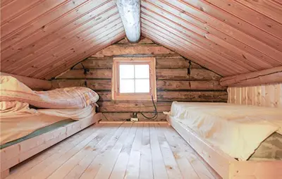 a bedroom with two beds in a wooden cabin at 4 Bedroom Stunning Home In Rendalen in Rendalen