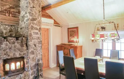 a dining room with a table and a stone fireplace at 4 Bedroom Stunning Home In Rendalen in Rendalen