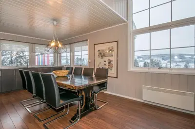 a dining room with a table and chairs and windows at Trysilfjell Apartment Hotel in Trysil