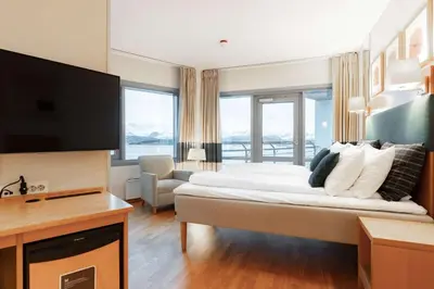 a hotel room with a large bed and a television at Scandic Seilet Hotel in Molde