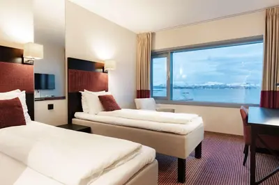 a hotel room with two beds and a large window at Scandic Seilet Hotel in Molde