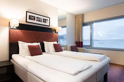 a hotel room with two beds and a large window at Scandic Seilet Hotel in Molde