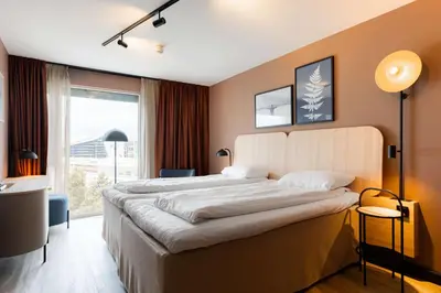 a hotel room with a large bed and a window at Scandic Nidelven in Trondheim