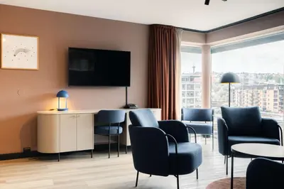 a hotel room with chairs and a flat screen tv at Scandic Nidelven in Trondheim