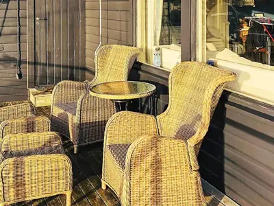 three wicker chairs and a table on a porch at 6 person holiday home in Urangsvåg in Steinsbø