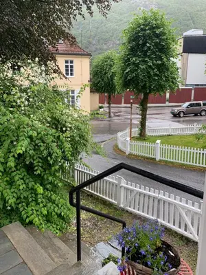a white fence and a white flower pot on the stairs at Høyanger 3 roms leilighet in Høyanger
