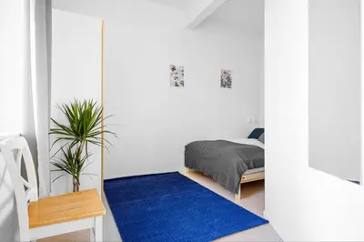a bedroom with a bed and a blue rug at Fabryka in Bergen