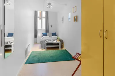 a living room with a couch and a green rug at Fabryka in Bergen