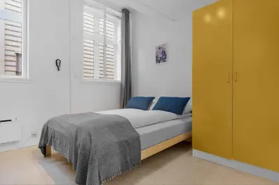 a bedroom with a bed and a yellow cabinet at Fabryka in Bergen