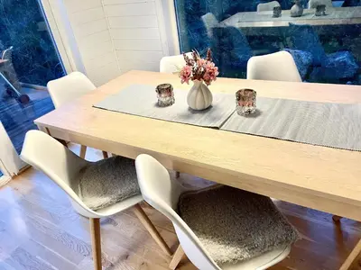 a dining room table with chairs and a vase with flowers at Fjellsporthytta nr. 4 in Sogndal