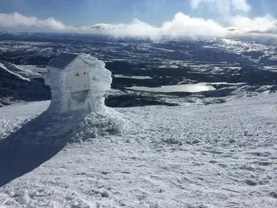 a snow covered hill with a view of a mountain at Kilen Lodge in Gaustablikk