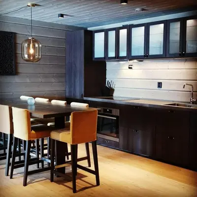 a kitchen with a table and chairs and a counter at Timblalodgen in Sogndal