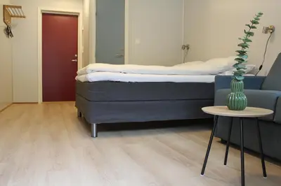 a bedroom with a bed and a table with a vase at Utvika Camping in Nes