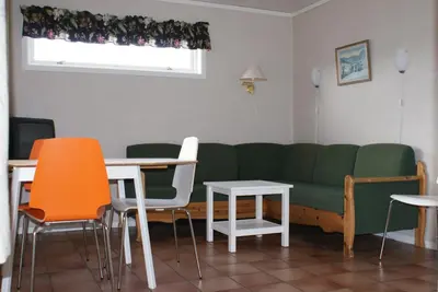a living room with a green couch and tables and chairs at Utvika Camping in Nes