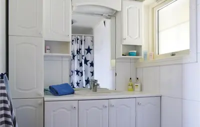 a white bathroom with a sink and a window at Gorgeous Home In Torangsvåg With Wifi in Skår