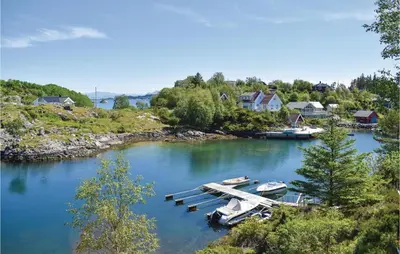 two boats are docked at a dock on a river at Gorgeous Home In Torangsvåg With Wifi in Skår