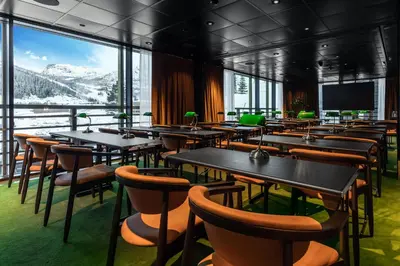 a dining room with tables and chairs and windows at Fýri Resort in Hemsedal