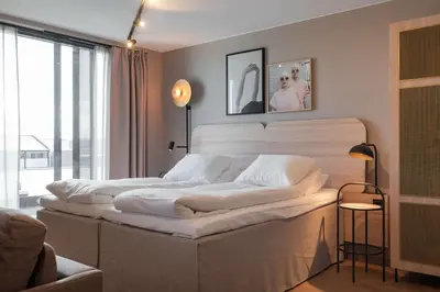 a bedroom with a large bed with white sheets at Scandic Hamar in Hamar