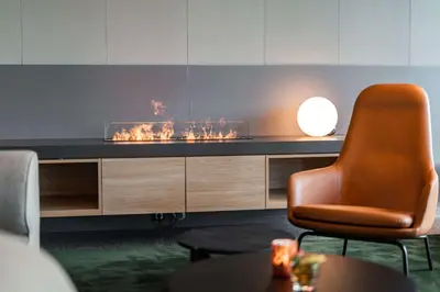 a living room with a chair and a fireplace at Scandic Hamar in Hamar