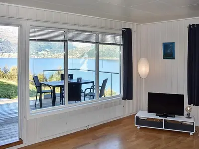 a living room with a table and a view of the water at 10 person holiday home in skei i jølster in Årdal