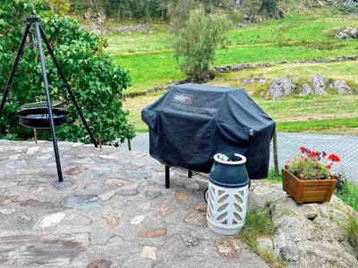 a black tent sitting on a rock with a flower pot at 9 person holiday home in Reksteren in Haukafer