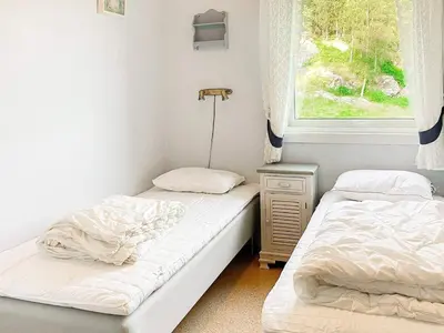 two beds in a room with a window at 9 person holiday home in Reksteren in Haukafer