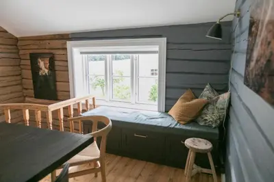 a room with a window with a couch and a table at Østigård 1810 in Åndalsnes