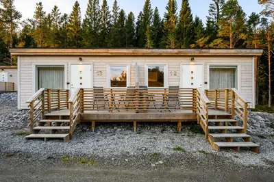 a building with wooden stairs in front of it at Korsbakken Camping in Isfjorden
