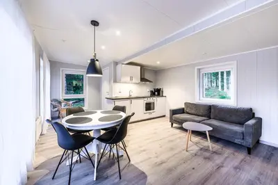 a living room with a couch and a table and chairs at Korsbakken Camping in Isfjorden