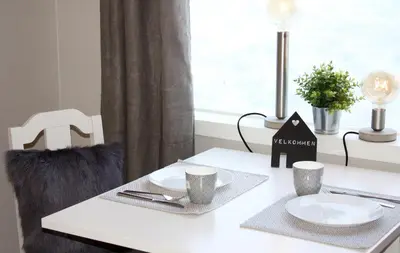 a white table with two plates and cups on it at Studioleilighet i Haukedalen in Holsen