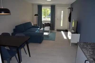 a living room with a blue couch and a table at Einemo Apartments in Lærdalsøyri