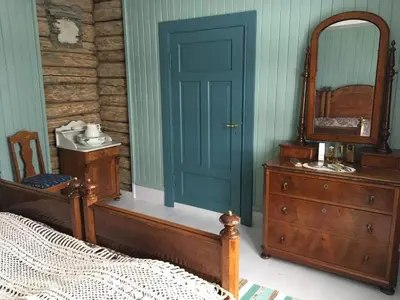 a bedroom with a bed and a mirror and a dresser at Skjeggestad Gjestehus in Ringebu