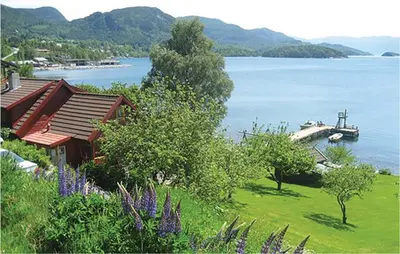 a house on the shore of a lake with a boat at Nice Home In Valen With Wifi in Valen