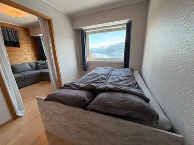 a bed in the corner of a room with a window at Studio Apartment in Haukedalen in Førde