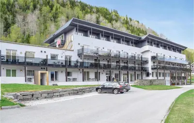 a large building with a car parked in front of it at Stunning Apartment In Vossestrand in Vossestrand