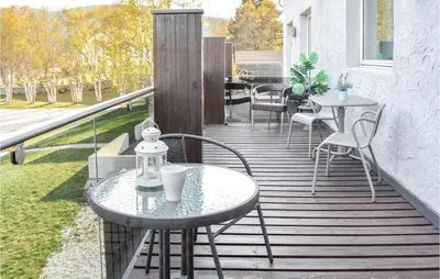 a wooden deck with tables and chairs on a balcony at Stunning Apartment In Vossestrand in Vossestrand
