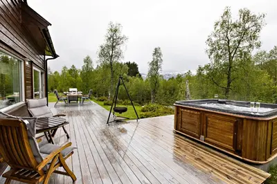 a jacuzzi tub on a wooden deck at Riverside in Hornindal