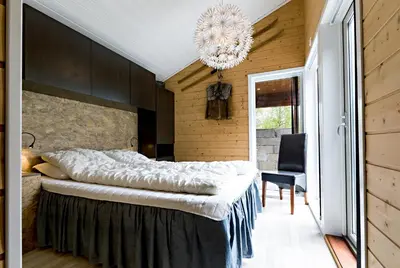 a bedroom with a large bed and a chandelier at Riverside in Hornindal
