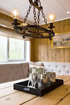 a chandelier hanging over a table with glasses on a tray at Riverside in Hornindal