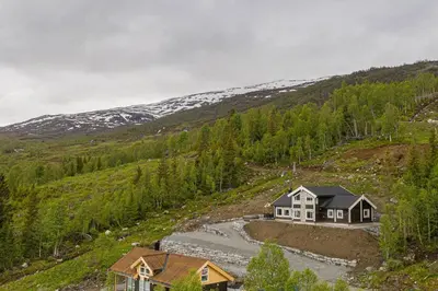 a house on the side of a hill with a river at Rolfhytta - Fosskamben 19 in Sogndal