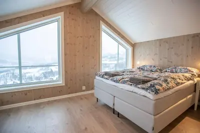 a bedroom with a bed and a large window at Rolfhytta - Fosskamben 19 in Sogndal