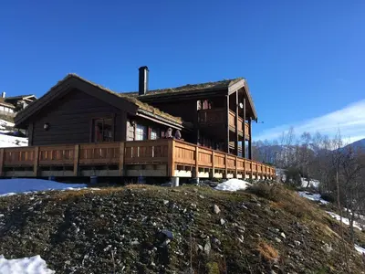 a large wooden house on top of a hill at Harpefossen Skisenter og Hyttegrend in Nordfjordeid
