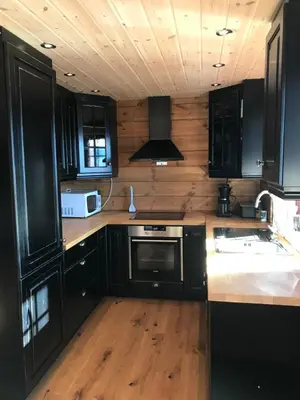 a kitchen with black cabinets and wooden floors at Harpefossen Skisenter og Hyttegrend in Nordfjordeid