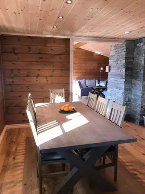 a dining room with a wooden table and chairs at Harpefossen Skisenter og Hyttegrend in Nordfjordeid