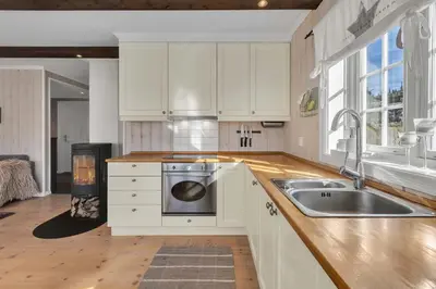 a kitchen with white cabinets and a sink and a stove at Leilighet Gaustablikk in Rjukan