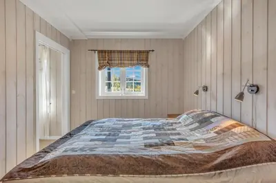 a bedroom with a large bed with a window at Leilighet Gaustablikk in Rjukan