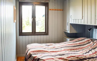 a bedroom with a bed with a blanket on it at 3 Bedroom Amazing Home In Sjusjøen in Sjusjøen