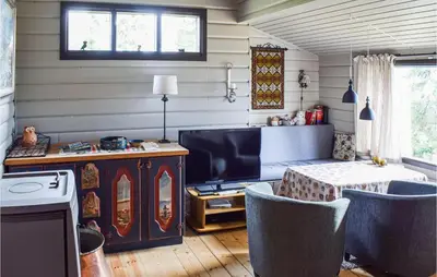 a living room with a tv and a table and chairs at 3 Bedroom Amazing Home In Sjusjøen in Sjusjøen
